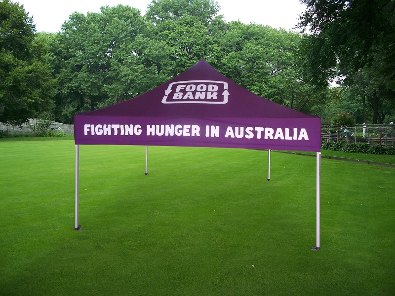 purple custom marquee sitting on top of a lush green field