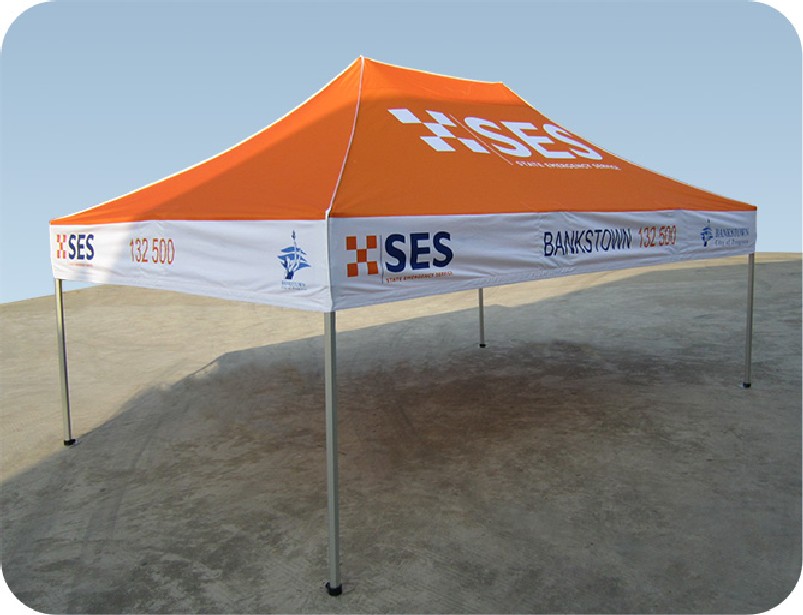 an orange and white custom marquee sitting on top of a sandy beach